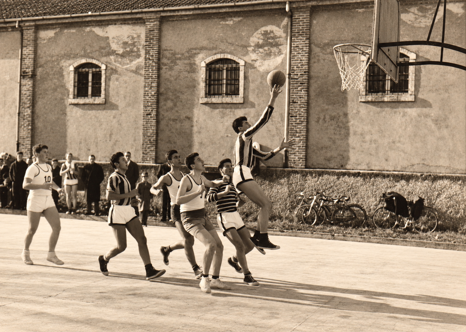 Azione di pallacanestro su un campo all’aperto in una fotografia storica