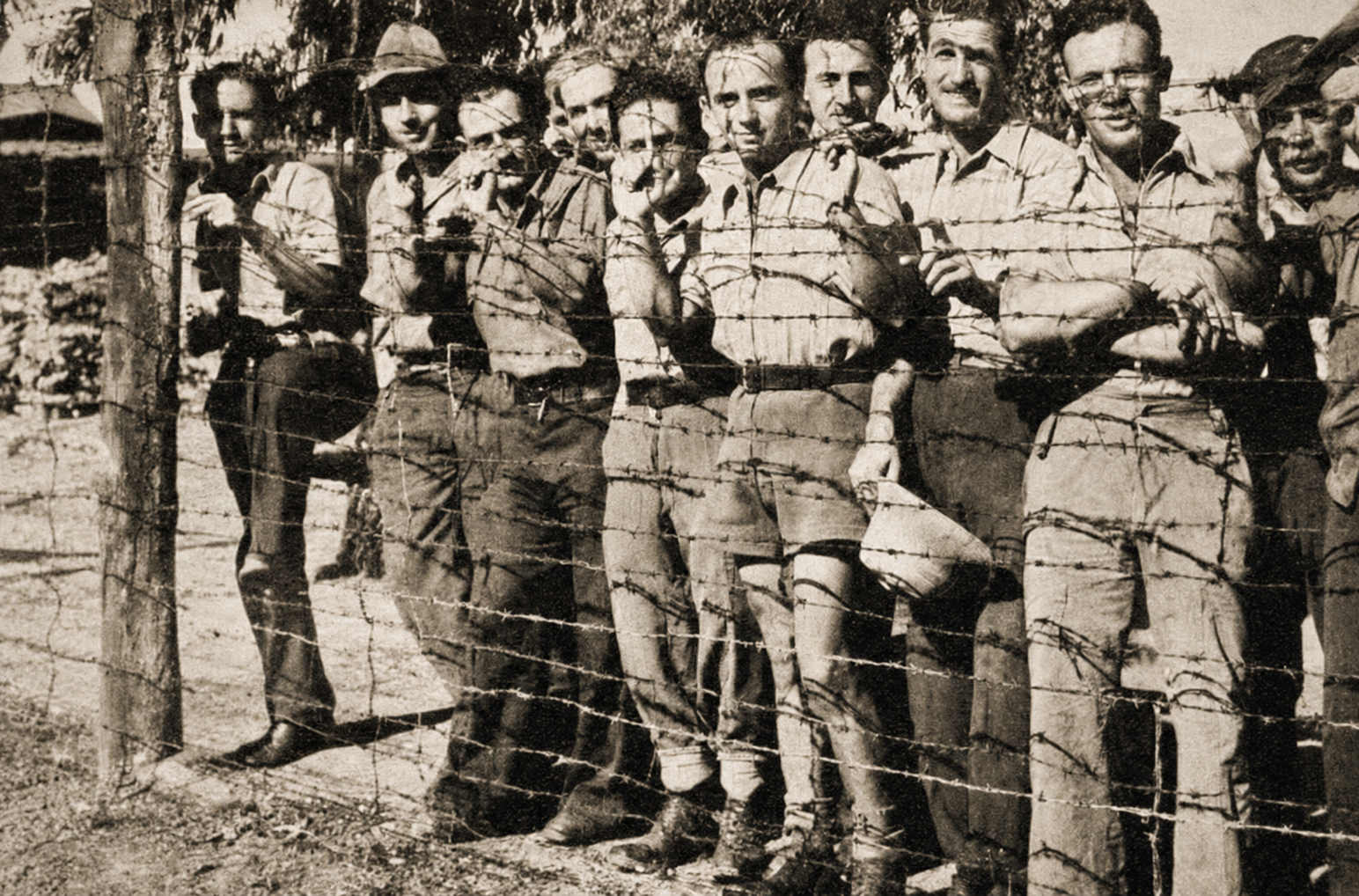 Internati militari italiani dietro il filo spinato in un campo di prigionia
